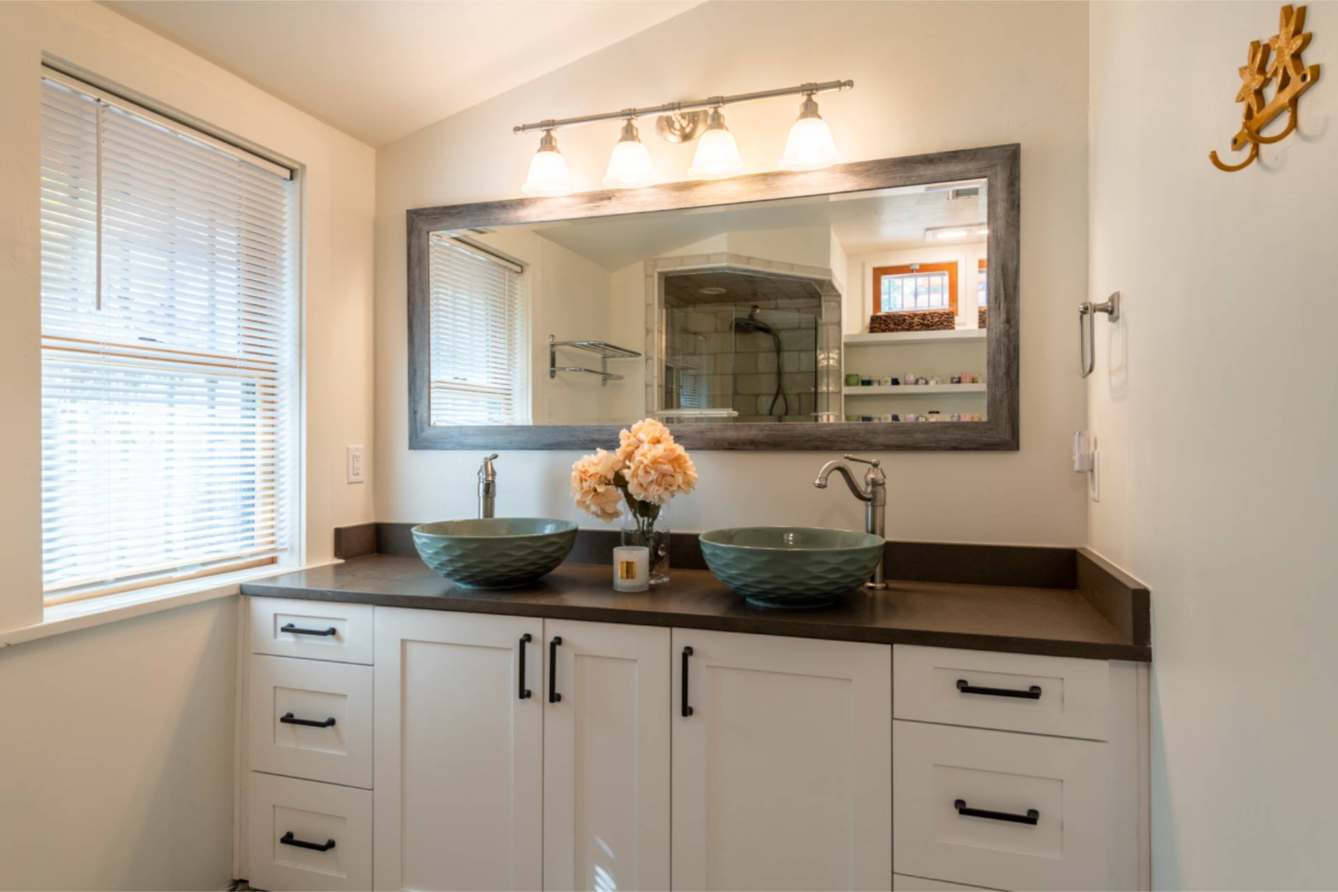 Diamond primary bath double vanity with white shaker cabinets, teal vessel sinks, and a wood-framed mirror