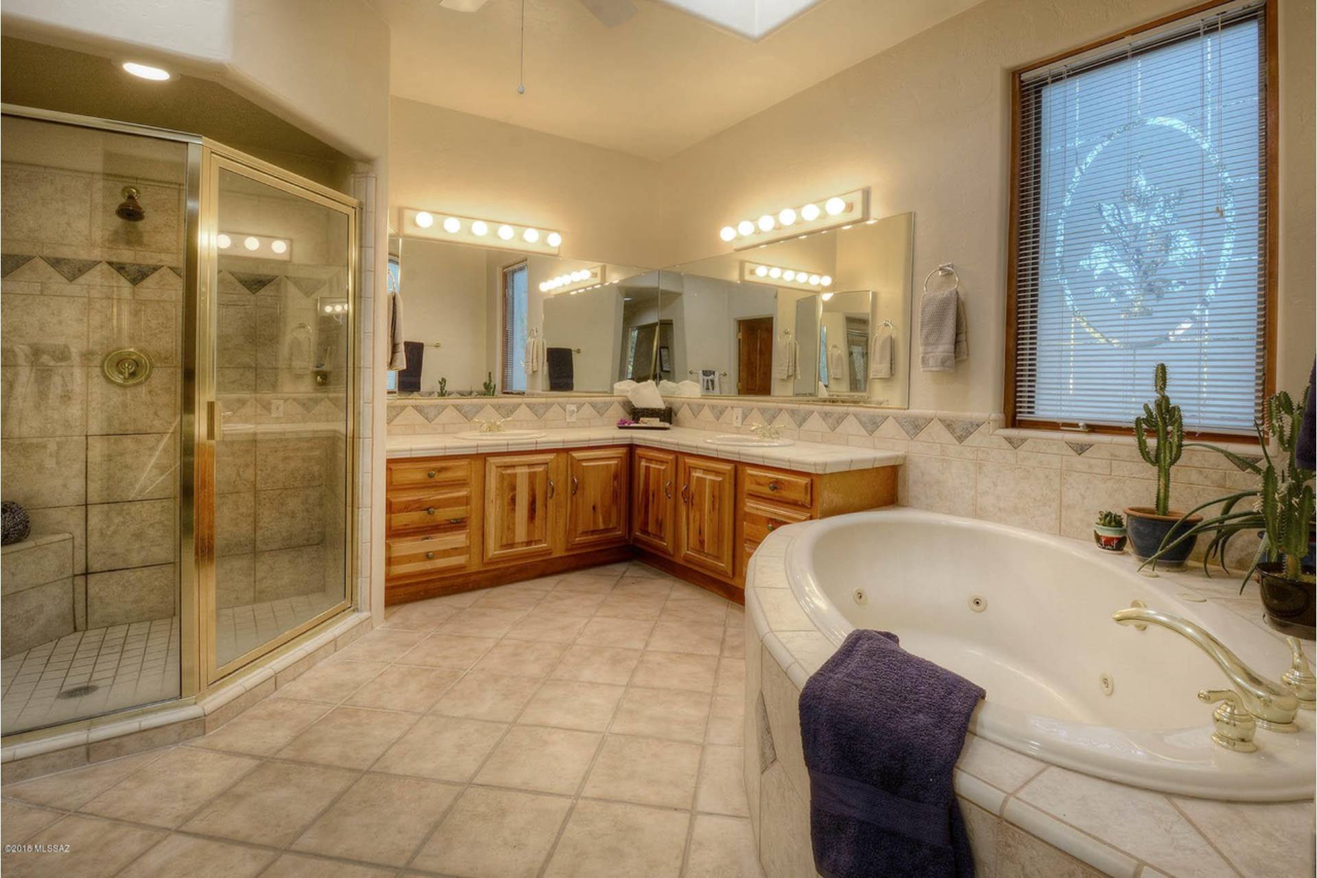 fisher-primary-bathroom-01 Fisher primary bath with a corner glass shower, alder vanity with tiled counter, framed mirror wall, and a jetted corner tub beneath a window