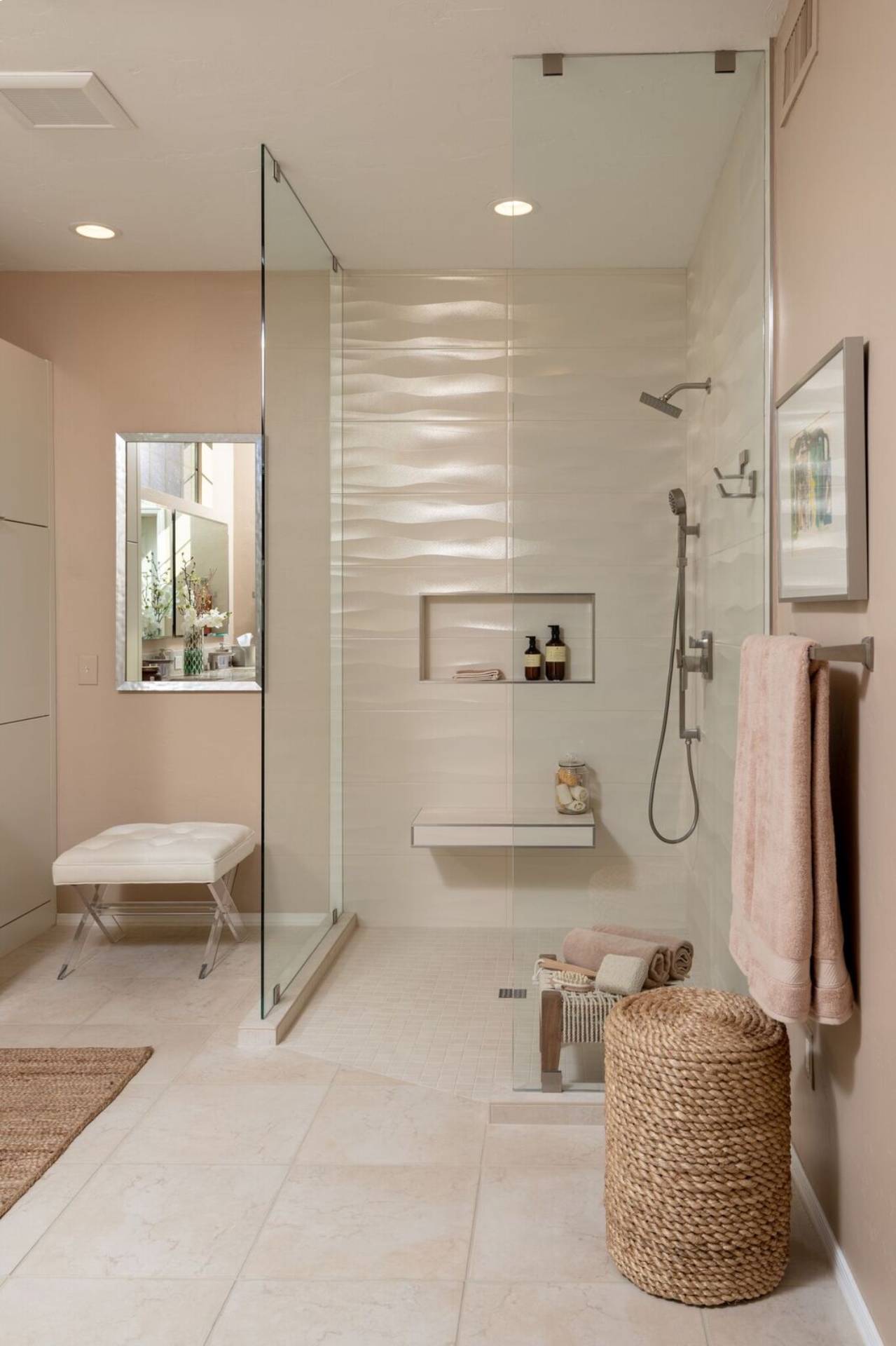 Schneider curbless walk-in shower with wavy white dimensional tile, a floating bench, and blush plaster walls